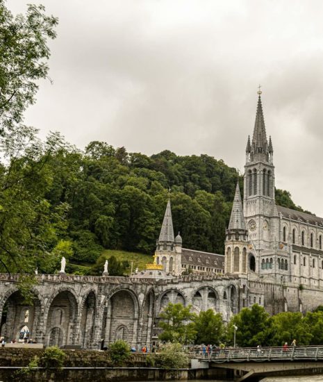 Stunning view of the Basilica of Our Lady of Lourdes against lush green landscape.